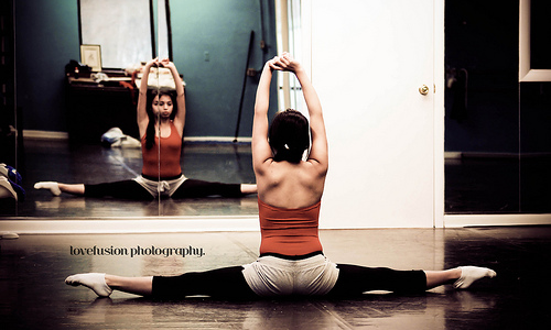 Spread your legs as wide as possible on the floor