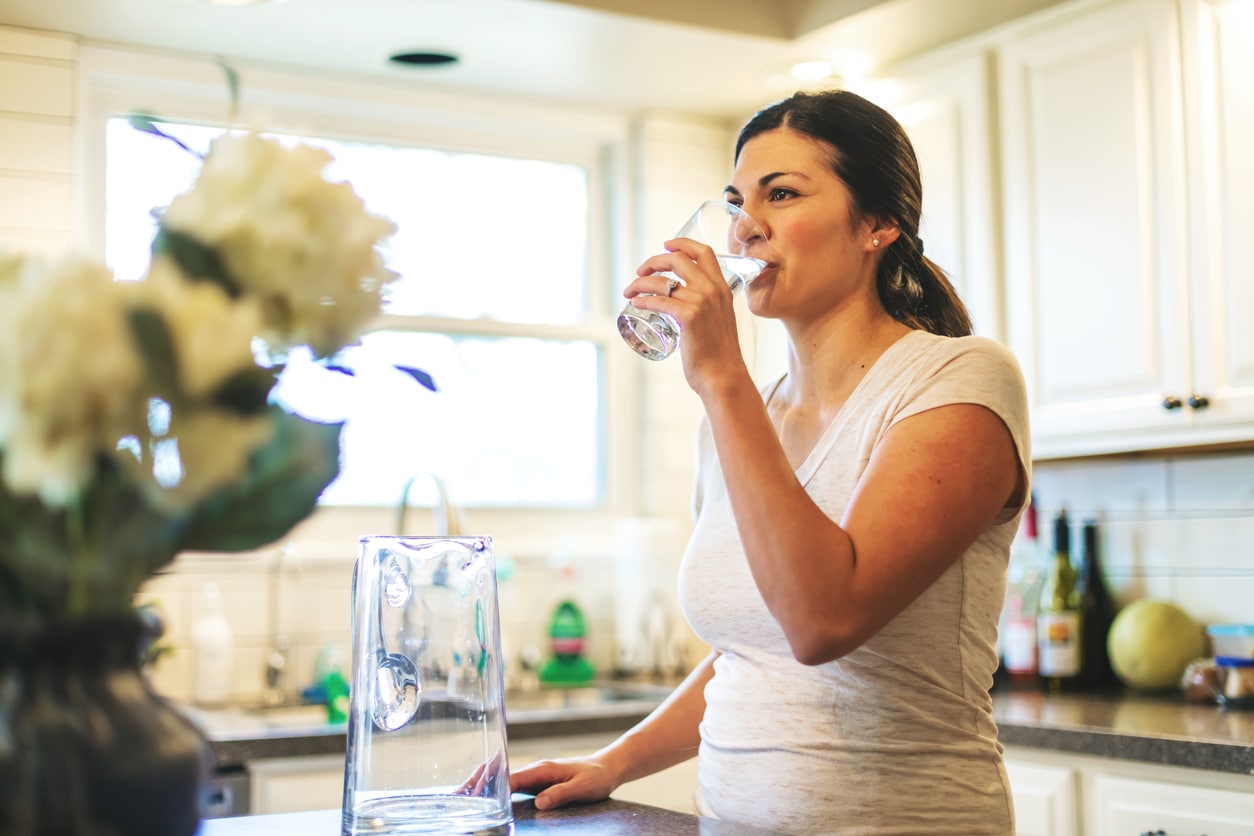 Top 3 Diet Mistakes That Will Make You Look Older 4 Woman in kitchen drinking water