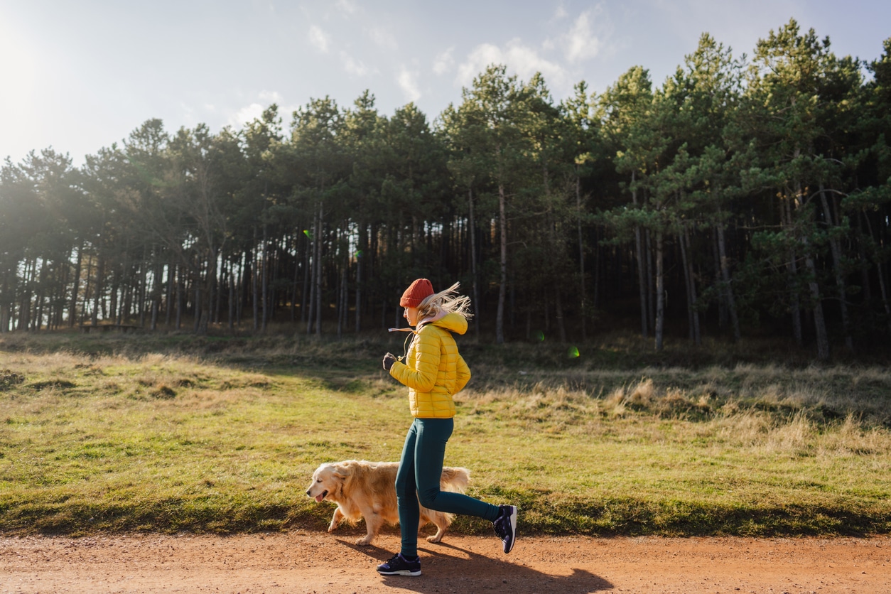 Woman running with dog in cold weather