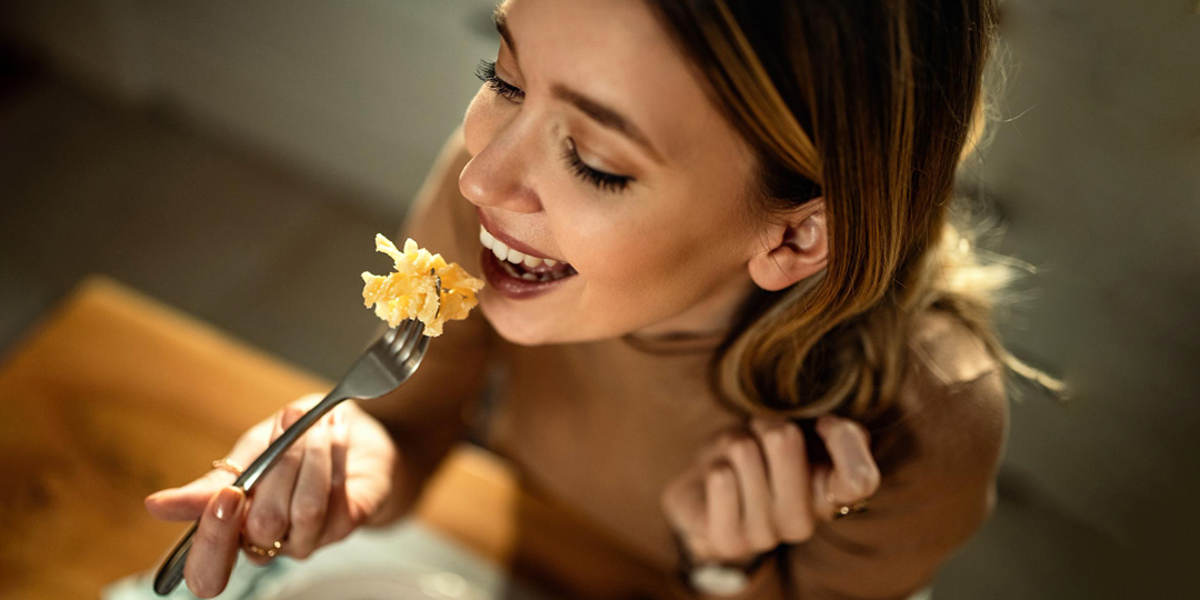 closeup young happy woman eating pasta dining table 1