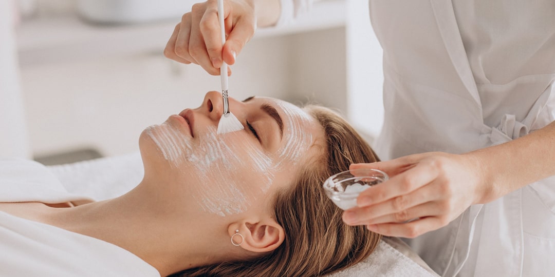 cosmetologist doing face treatment applying face mask min
