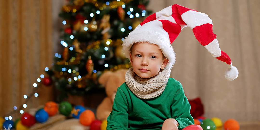 cute little boy santa s hat with christmas tree background