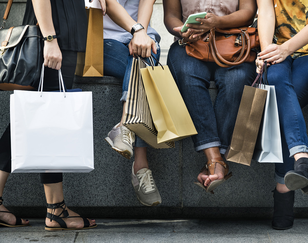 women sitting with shopping bags