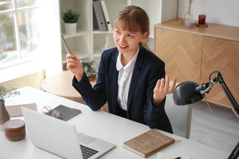 A woman dressed in a suit conducting an informational interview online