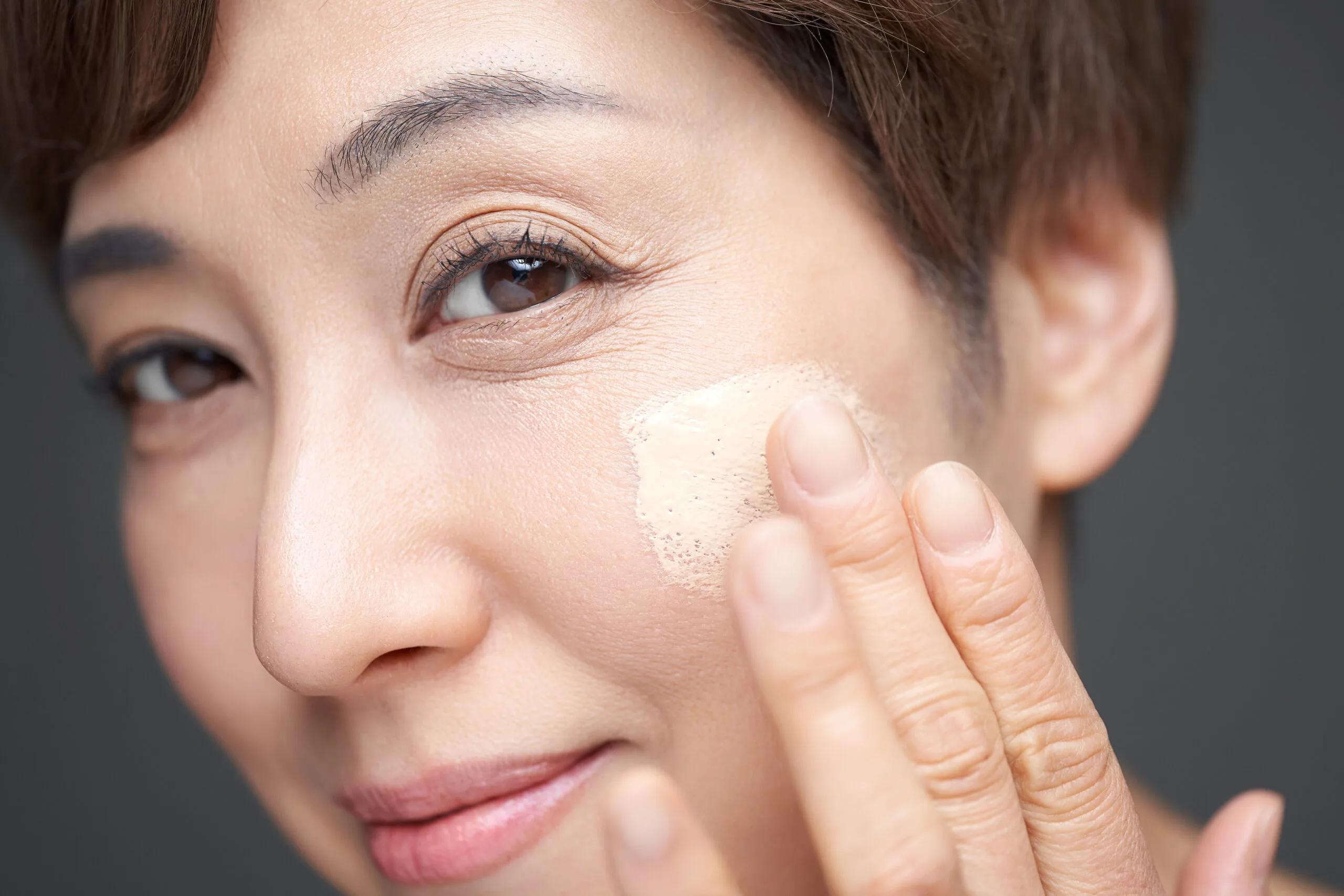 Woman putting on foundation scaled 1